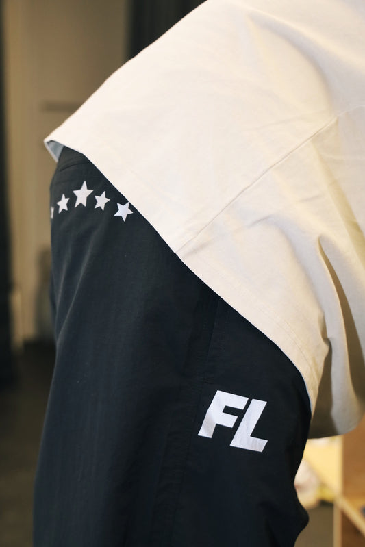 Model posing showing both logos of FL Warm Up Pants.